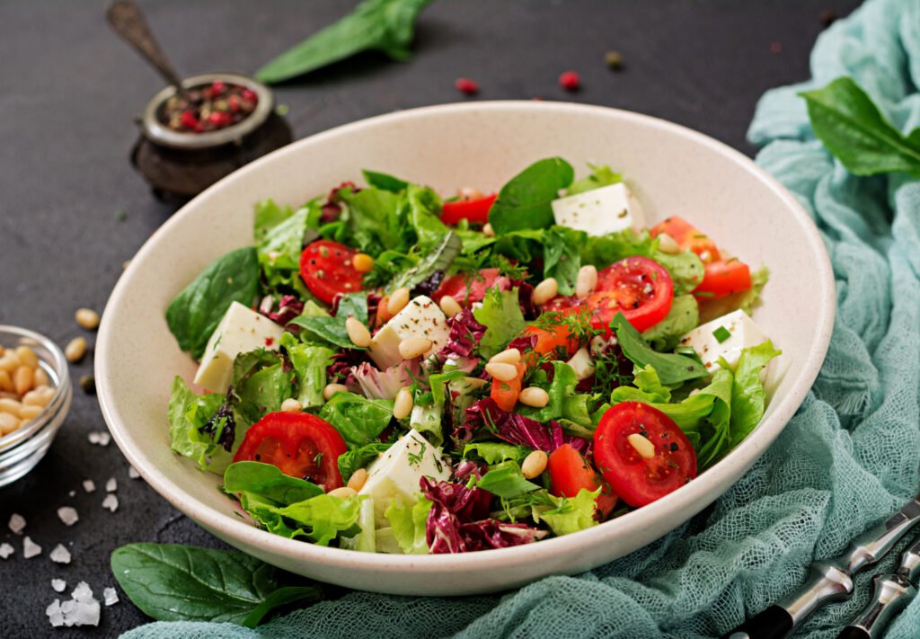 salada-usos-e-beneficios — tigela com salada verde colorida, crocante, com legumes e molho cítrico