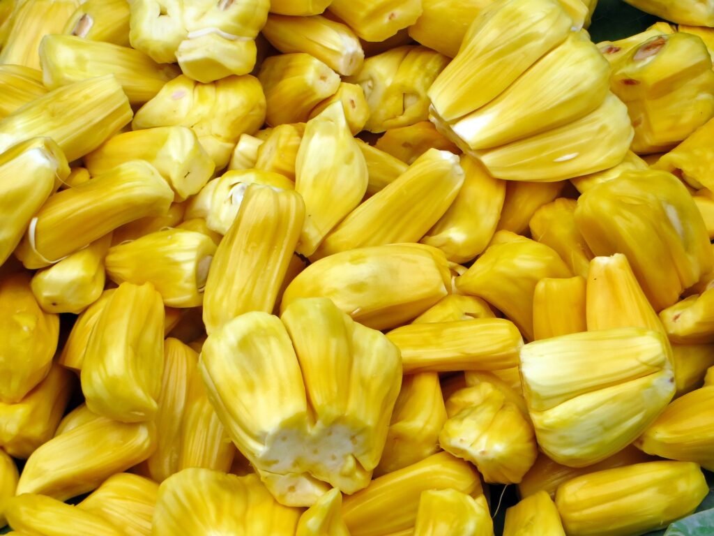 jaca-beneficios-e-composicao fruto grande aberto com gomos amarelos, jaca madura rica em fibras, vitamina C e potássio