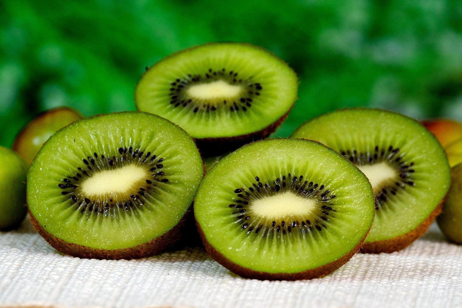 kiwi-beneficios-e-composicao fruta kiwi verde fatiada, polpa vibrante rica em vitamina C, fibras e potássio - ideal para sucos, saladas e sobremesas