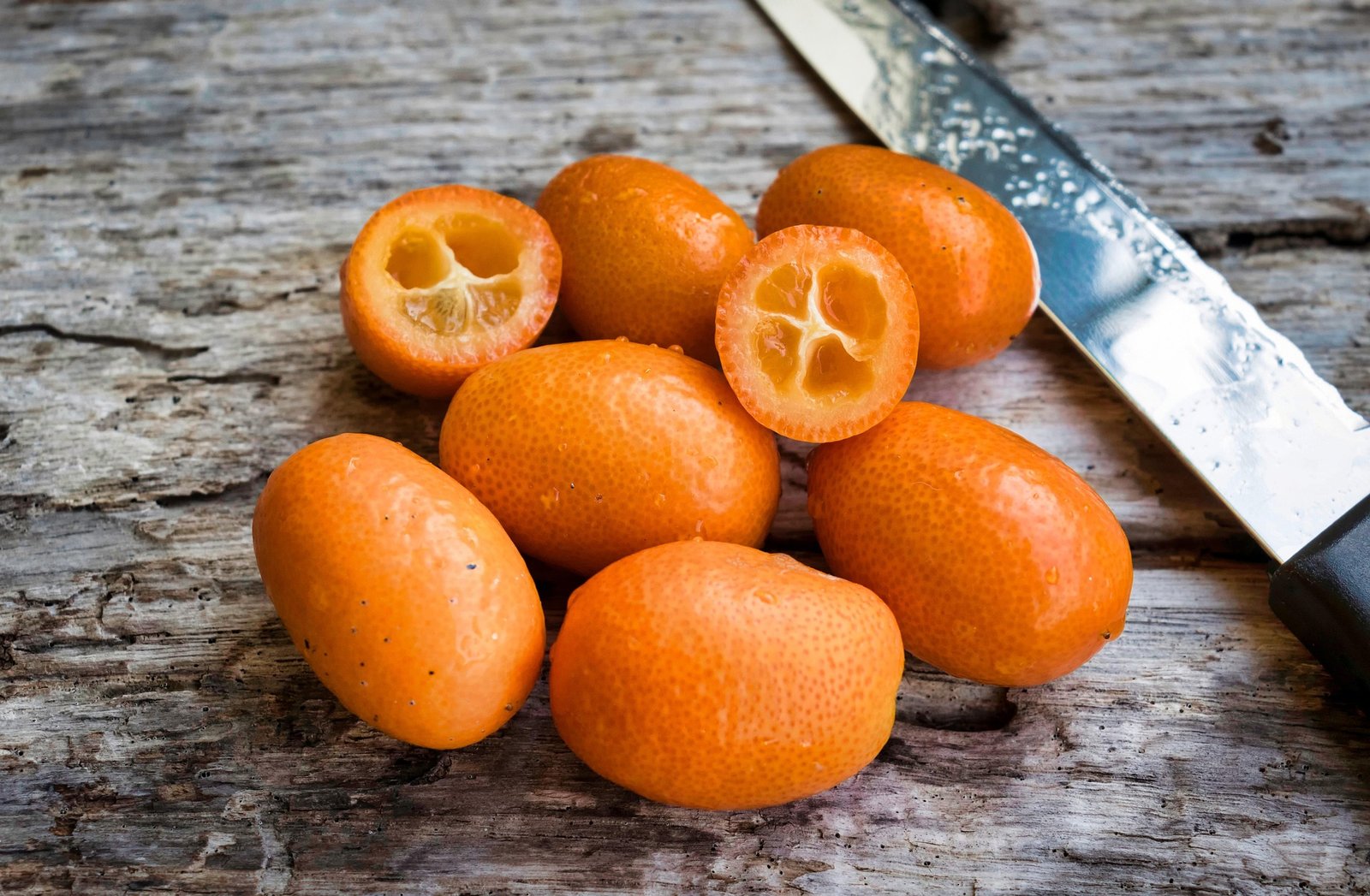 kumquat-beneficios-e-composicao kumquat kinkan quinoto inteiros e fatiados, casca comestível rica em vitamina C e fibras - ideal para sucos, saladas e sobremesas