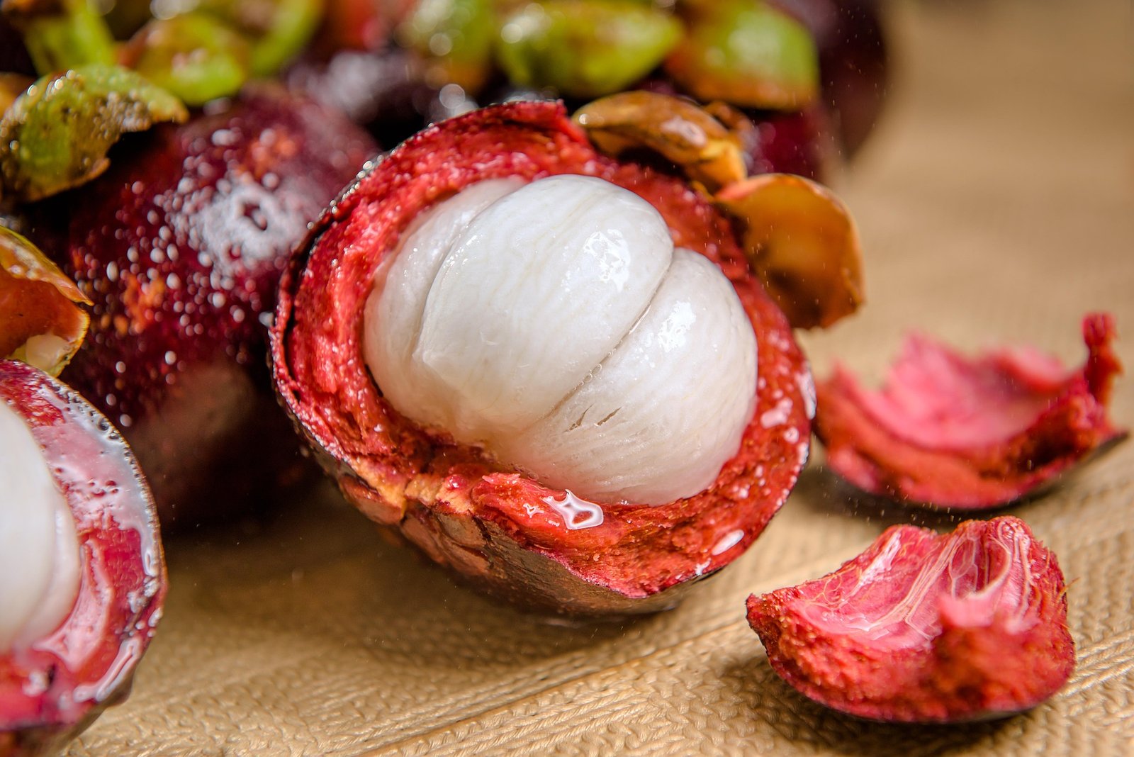 mangostao-beneficios-e-composicao mangostões inteiros e abertos - gomos brancos suculentos - fruta doce, rica em vitamina C e fibras - ideal para sobremesas leves