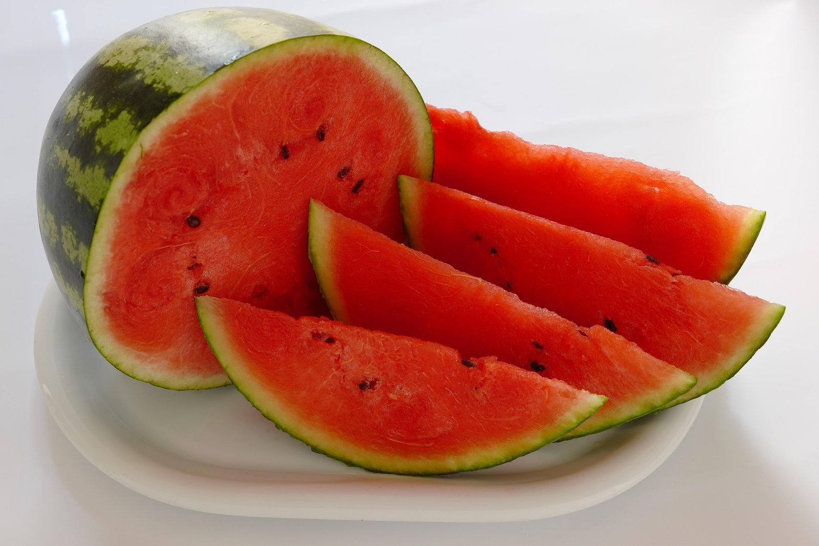 melancia-beneficios-e-composicao melancia inteira e fatiada, polpa vermelha suculenta com sementes, fruta hidratante, rica em vitamina C e potássio, ideal para verão