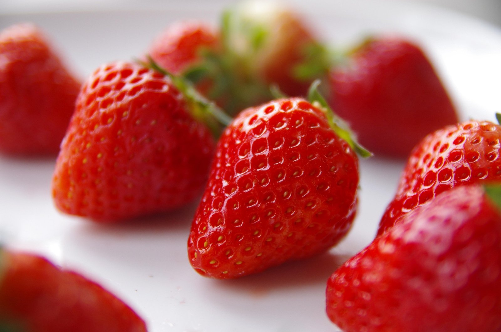 morango-beneficios-e-composicao morangos frescos inteiros e fatiados, fruta rica em vitamina C e fibras, ideal para bowls, smoothies, saladas e sobremesas leves