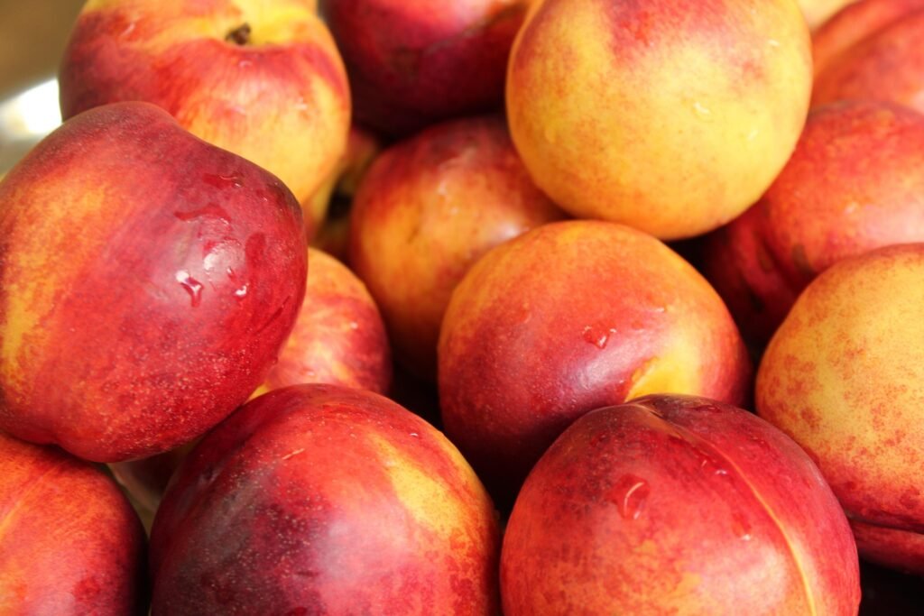 nectarina-beneficios-e-composicao nectarinas maduras inteiras e fatiadas - polpa suculenta - fruta doce de baixa caloria, rica em fibras e vitaminas - ideal para bowls e sobremesas