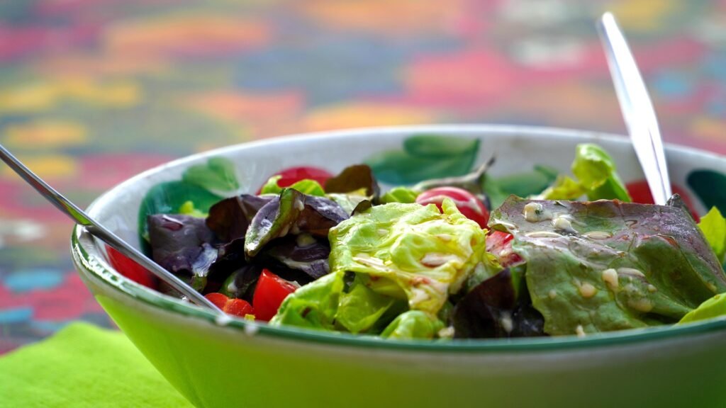 salada-usos-e-beneficios — tigela com salada verde colorida, crocante, com legumes e molho cítrico