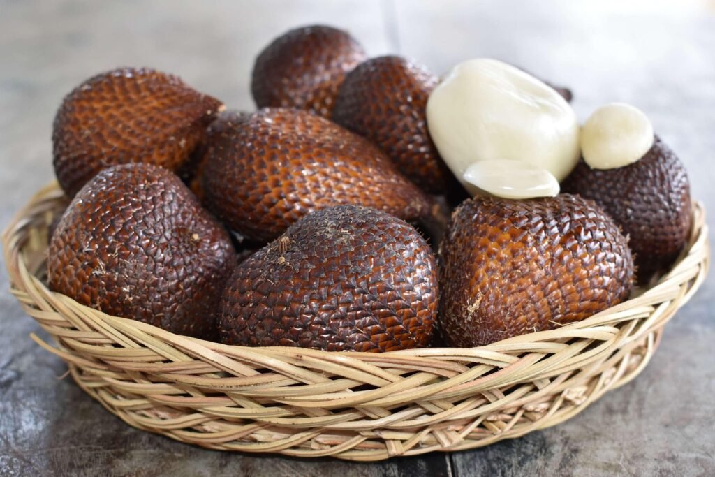 salak-beneficios-e-composicao fruta de casca escamosa marrom, gomos claros - close da textura e porções para sucos, saladas e sobremesas