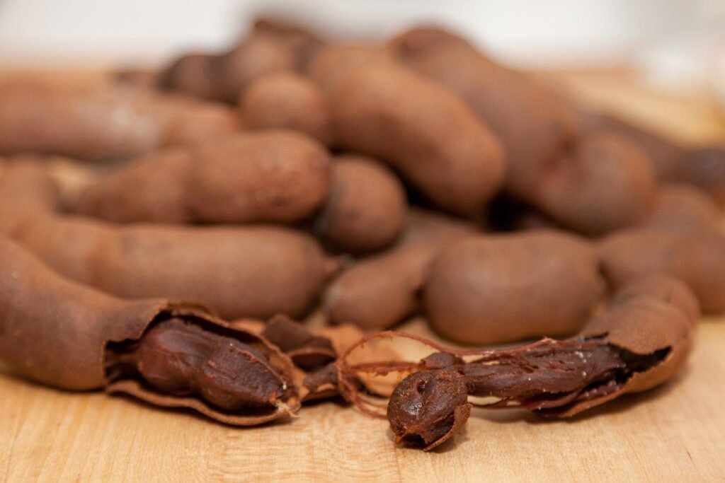 tamarindo-beneficios-e-composicao vagens marrons quebradas, polpa azedo-doce em destaque - porções prontas para sucos, chutneys e molhos