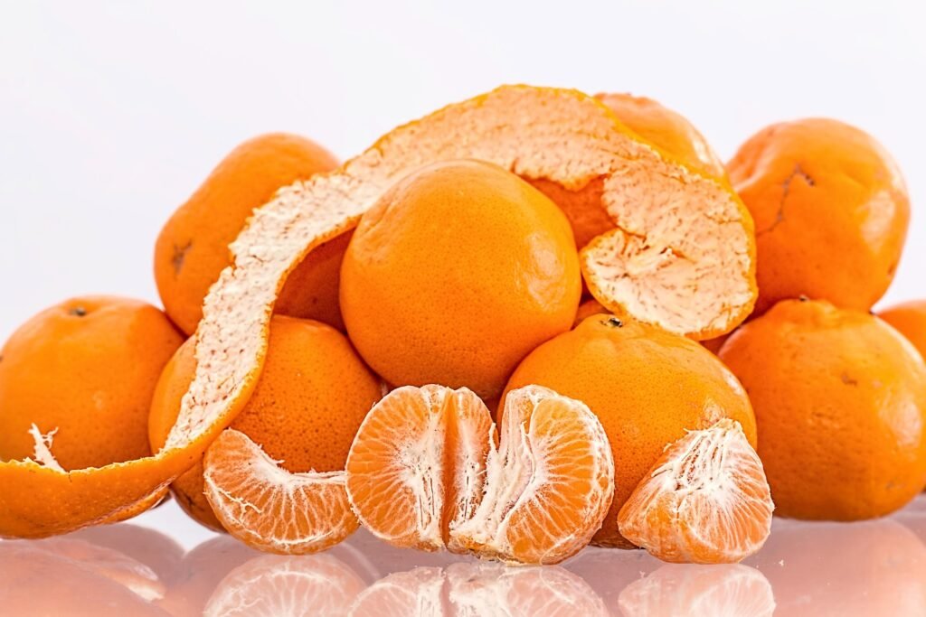 tangerina-beneficios-e-composicao gomos e cascas de tangerina frescas - close para sucos, chás, saladas e sobremesas