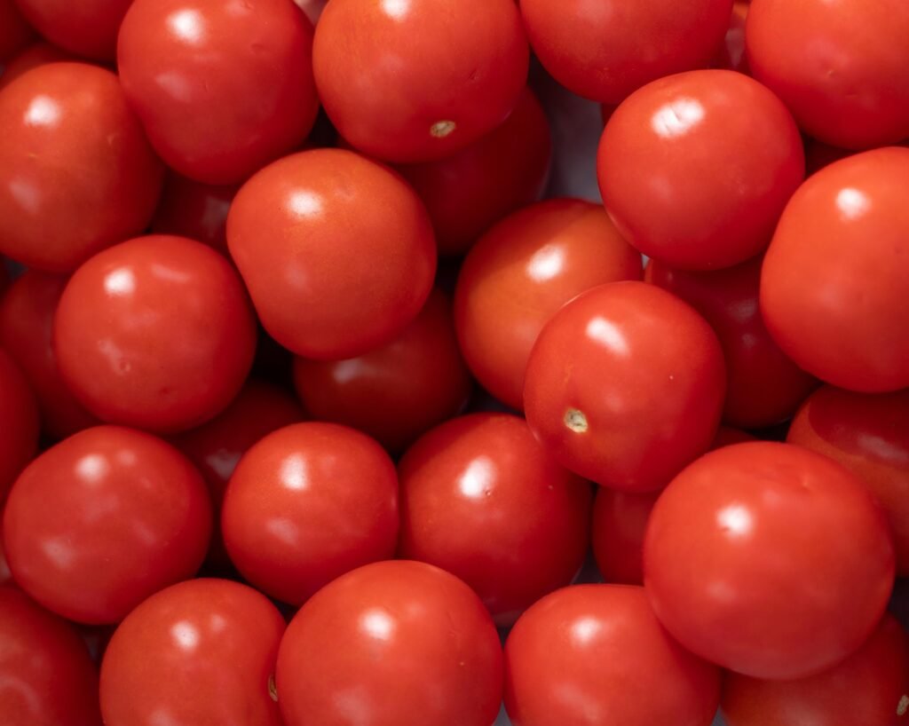 tomate-beneficios-e-composicao tomates vermelhos frescos em close, gomos e molho - ideal para saladas, molhos, sopas e sucos