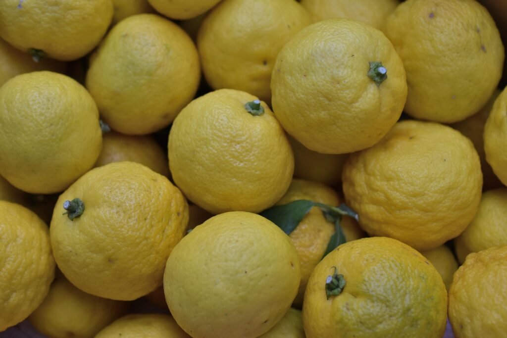 yuzu-beneficios-e-composicao fruta yuzu fresca com casca rugosa e meia-lua cortada - cítrico aromático rico em vitamina C e ideal para chás e temperos